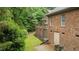 The brick house features a well manicured lawn area, a brick patio, and a walk-out basement entrance at 414 Bakewell Ct, Wake Forest, NC 27587