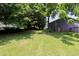 Spacious backyard featuring lush green grass and mature trees offering plenty of shade at 420 E Grandview Ave, Liberty, NC 27298