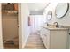 Bright bathroom featuring dual vanity sinks, granite countertops, and a closet with built-in storage at 420 E Grandview Ave, Liberty, NC 27298