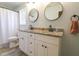 Well-lit bathroom featuring dual sinks with granite countertops and modern black hardware fixtures at 420 E Grandview Ave, Liberty, NC 27298