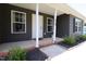 Inviting front porch featuring classic columns with lush landscaping and neutral tones at 420 E Grandview Ave, Liberty, NC 27298