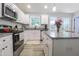 Bright kitchen with granite counters, white cabinets, stainless appliances, and center island at 420 E Grandview Ave, Liberty, NC 27298