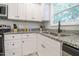 Well-lit kitchen featuring granite countertops, white cabinets, and stainless steel appliances at 420 E Grandview Ave, Liberty, NC 27298