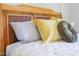 Close up of main bedroom bedding with white, yellow, and green pillows against a wood headboard at 420 E Grandview Ave, Liberty, NC 27298