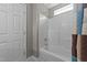 Bathroom with neutral walls, white tile, white door, and tub with curtain at 4213 Stoneford Trace Dr, Raleigh, NC 27616