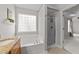 Bright bathroom featuring a soaking tub with a glass block window and granite countertops at 4213 Stoneford Trace Dr, Raleigh, NC 27616