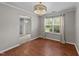 Charming dining room features hardwood floors, a chandelier, and a large window with serene backyard views at 4213 Stoneford Trace Dr, Raleigh, NC 27616