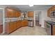 This kitchen features wood cabinets, stainless steel appliances, and a view into the home's foyer at 4213 Stoneford Trace Dr, Raleigh, NC 27616