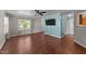 Bright living room featuring hardwood floors, a ceiling fan, a large window, and a modern color scheme at 4213 Stoneford Trace Dr, Raleigh, NC 27616