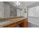 Bathroom with double sink vanity with granite counters, a tub, and transom glass block window at 4213 Stoneford Trace Dr, Raleigh, NC 27616
