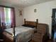 Cozy bedroom featuring natural light, a queen-sized bed, and a comfortable recliner, ideal for relaxation at 45 Perkinson St, Kittrell, NC 27544