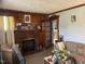 Cozy living room featuring a brick fireplace, wood paneling, comfortable seating, and decorative accents for an inviting atmosphere at 45 Perkinson St, Kittrell, NC 27544