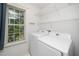 Convenient laundry room with a window and white appliances for easy chore days at 5006 Silhouette Dr, Durham, NC 27713