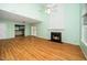 Bright living room with a fireplace, wood floors, and a view of the kitchen at 5006 Silhouette Dr, Durham, NC 27713