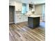 Bright kitchen featuring white cabinets, island, and herringbone backsplash at 505 E Canary St, Dunn, NC 28334