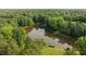 Aerial view of a serene lake surrounded by lush green forests on a sunny day at 5344 Mill Dam Rd, Wake Forest, NC 27587