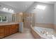 Bright bathroom featuring tile flooring, a glass enclosed shower, and a soaking tub under a skylight at 5344 Mill Dam Rd, Wake Forest, NC 27587
