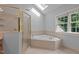 This well-lit bathroom features a soaking tub, a shower, and bright natural light from a window at 5344 Mill Dam Rd, Wake Forest, NC 27587