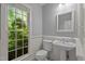 Charming powder room with a pedestal sink and a lovely window view at 5344 Mill Dam Rd, Wake Forest, NC 27587