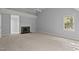 An empty bedroom with a carpeted floor, a fireplace and a pair of windows to let the sunshine in at 5344 Mill Dam Rd, Wake Forest, NC 27587