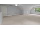 A spacious bonus room with neutral carpeting offers versatility for recreation or relaxation at 5344 Mill Dam Rd, Wake Forest, NC 27587