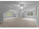 A large bonus room with neutral carpets and multiple windows offers ample natural light at 5344 Mill Dam Rd, Wake Forest, NC 27587