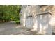 Attached two-car garage with white doors and exterior lighting on a sunny day at 5344 Mill Dam Rd, Wake Forest, NC 27587