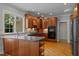 Kitchen featuring wood cabinets, tile backsplash, stainless steel appliances, and an island with bar seating at 5344 Mill Dam Rd, Wake Forest, NC 27587