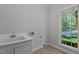 The laundry room has a utility sink, window, and tile flooring, providing functionality and natural light at 5344 Mill Dam Rd, Wake Forest, NC 27587
