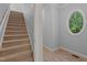 Carpeted staircase and hall with unique oval window providing natural light at 5344 Mill Dam Rd, Wake Forest, NC 27587
