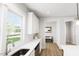 Bright, modern kitchen featuring white cabinetry, backsplash, and stainless steel sink with hardwood floors at 537 Folk Song Way, Wendell, NC 27591