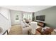 Bright living room featuring white sofa, modern furniture, large windows, and hardwood flooring at 537 Folk Song Way, Wendell, NC 27591