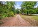 Long gravel driveway flanked by lush greenery, leading to the property at 5601 Buffaloe Rd, Raleigh, NC 27616