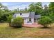 Charming home exterior with a spacious wooden deck, screened porch, and lush greenery at 5601 Buffaloe Rd, Raleigh, NC 27616