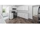 Bright kitchen with white cabinets, black appliances, and modern flooring at 5601 Buffaloe Rd, Raleigh, NC 27616