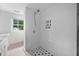 Modern shower with white subway tile, a rainfall shower head and a contrasting mosaic tiled floor and niche at 5601 Buffaloe Rd, Raleigh, NC 27616