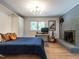 Comfortable bedroom with a gray brick fireplace, workstation, closet, and a mid-century modern light fixture at 5809 Kimbal St, Raleigh, NC 27606