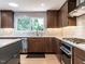 The kitchen features updated appliances, modern cabinetry and a large window with a treed view at 5809 Kimbal St, Raleigh, NC 27606