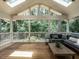 Bright screened porch with vaulted ceiling, ample seating and views of wooded backyard at 5809 Kimbal St, Raleigh, NC 27606