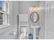 Charming bathroom with a pedestal sink, decorative mirror, and built-in shelving for storage at 602 Dunbar St, Durham, NC 27701