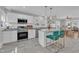 Bright and airy kitchen featuring white cabinets, stainless steel appliances, and a center island with stylish stools at 602 Dunbar St, Durham, NC 27701