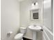 Half bathroom features a pedestal sink, decorative mirror and a toilet at 6536 Perry Creek Rd, Raleigh, NC 27616