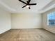 Empty room with tray ceilings, ceiling fan, carpet, and window for natural light in home at 6536 Perry Creek Rd, Raleigh, NC 27616