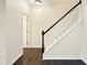 A home's entryway features dark wood floors and a staircase with white risers and a dark banister at 6536 Perry Creek Rd, Raleigh, NC 27616