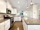 Bright kitchen features white cabinets, stainless steel appliances, granite countertops, and an island at 6536 Perry Creek Rd, Raleigh, NC 27616