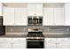 Modern kitchen featuring white cabinets, stainless steel appliances, and granite countertops at 6536 Perry Creek Rd, Raleigh, NC 27616