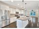 Open kitchen with white cabinets, stainless steel appliances, granite countertops, and hardwood floors at 6536 Perry Creek Rd, Raleigh, NC 27616