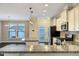 Bright open kitchen features white cabinets, granite countertops, and stainless steel appliances at 6536 Perry Creek Rd, Raleigh, NC 27616