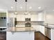 Spacious kitchen with white cabinets, stainless steel appliances, a granite island, and tile backsplash at 6536 Perry Creek Rd, Raleigh, NC 27616