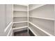 Spacious walk-in pantry features ample white shelving for organized storage and dark wood floor at 6536 Perry Creek Rd, Raleigh, NC 27616
